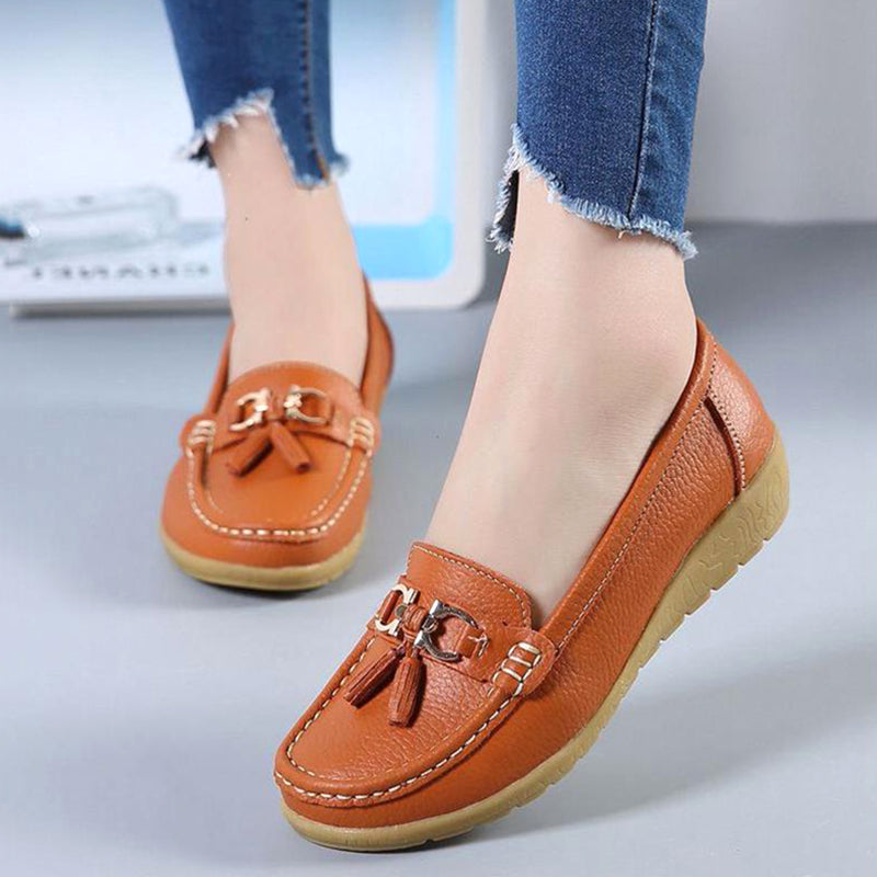Woman wearing orange genuine leather slip-on loafers for everyday comfort.
