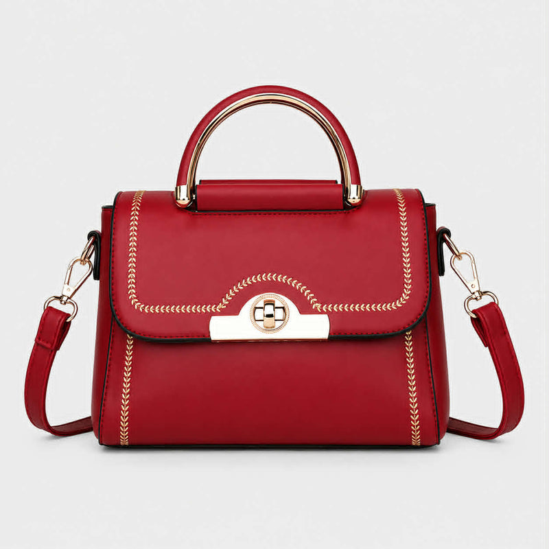 Red structured crossbody handbag with gold-tone handle and decorative stitching.
