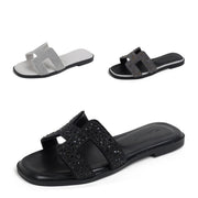 Women’s black rhinestone slide sandals with sparkling crystal straps on a white background
