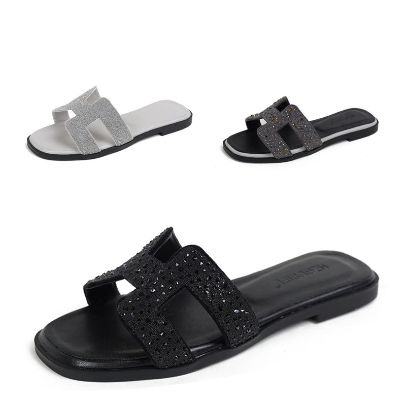 Women’s black rhinestone slide sandals with sparkling crystal straps on a white background

