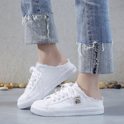 Woman wearing white canvas sneakers paired with casual everyday outfit.
