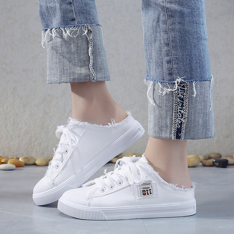 Woman wearing white canvas sneakers paired with casual everyday outfit.
